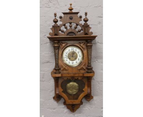 An early 20th century mahogany cased 8 day drop dial wall clock with enamel chapter ring with carved leaf decoration.