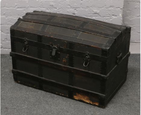 A metal bound dome top travel trunk.