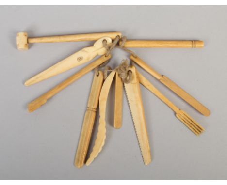 A collection of Victorian ivory teething bars formed as miniature tools.