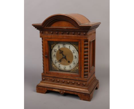 An 8 day walnut bracket clock with dome top.Condition report intended as a guide only.Missing finial.