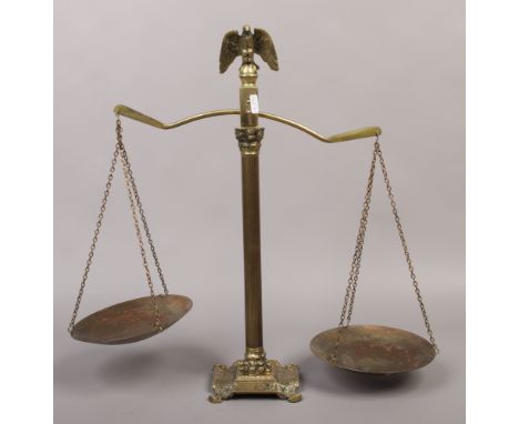 A set of brass scales with eagle finial and raised on a Corinthian column.