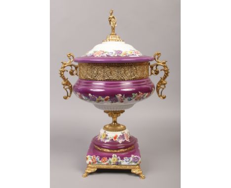 A decorative porcelain centrepiece purple ground with gilt and floral decoration and figural finial.