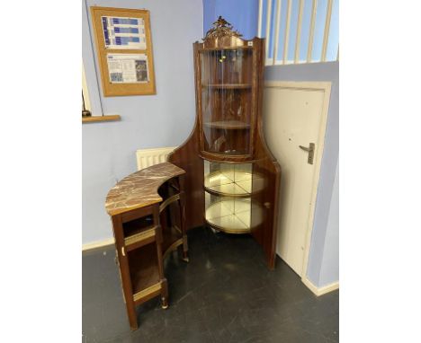 A Louis XV style marble corner vitrine, with bow front glass door, below a decorative panelled door, opening to reveal a fitt