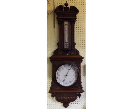 An aneroid barometer, with thermometer, in a carved oak case, 98 cm high, and a mantel clock (2)