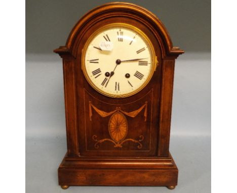 An Edwardian mantel clock, with Arabic numerals, fitted an eight day movement striking on a gong, in an inlaid mahogany case,
