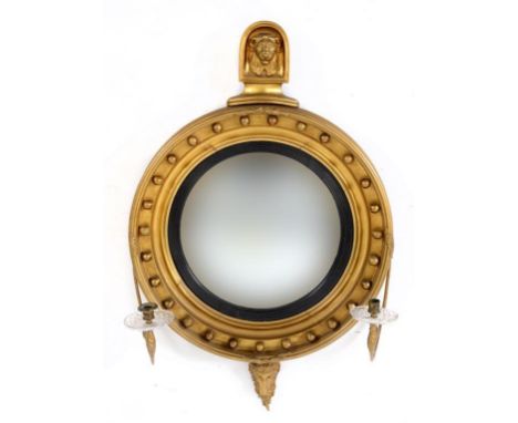 A 19th century mahogany girondale, the lion mask surmount above a convex mirror within a ball stud frame, terminating in a ra