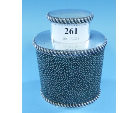A silver coloured metal tea caddy, of oval form, with shagreen style decoration, 11 cm high