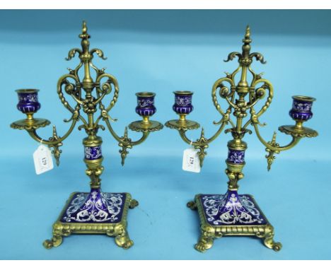 A pair of Limoges style enamel and gilt metal two branch candelabra, on a square base, 34.5 cm high (some repair) (2)