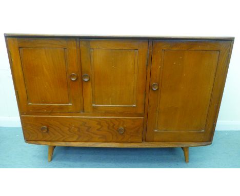 A blonde Ercol elm sideboard with an arrangement of three cupboards and a drawer, raised on tapered legs&nbsp; 32"h&nbsp; 45"