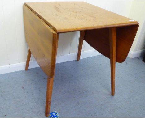 A blonde Ercol elm dining table, raised on square, tapered legs&nbsp; 30"h&nbsp; 55"w (open) 