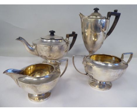 An Edwardian four piece silver tea set of pedestal lamp design, comprising a teapot with a swept spout, insulated handle and 