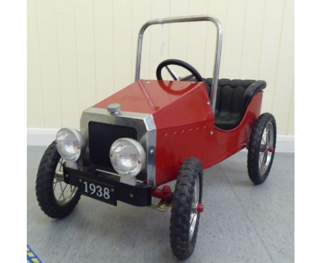 A painted model pedal car, in the manner of a veteran vehicle with red livery and spoked rubber wheels&nbsp; 33"L overall 
