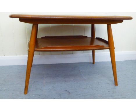 A blonde Ercol elm two tier coffee table, raised on elliptically turned legs&nbsp; 18"h&nbsp; 27"w 