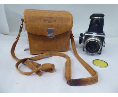 A Hasselblad 1000F camera, in a stitched tan hide case 