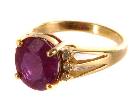 An 18ct gold ruby and diamond dress ring, the large oval cut ruby in four claw setting flanked by three small round cut diamo