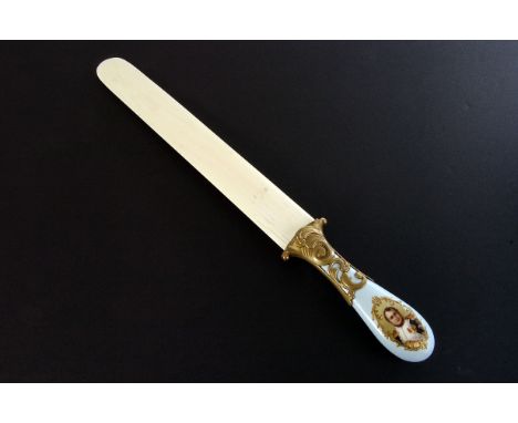 A 19th century ivory and porcelain page turner, the pale blue ground porcelain handle having panel with portrait of a young N