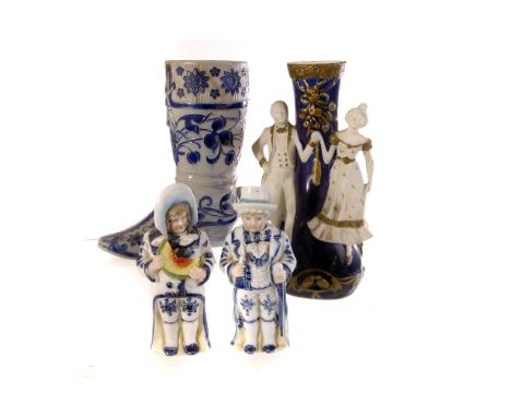 A porcelain figural jug, the Royal Blue glaze with applied male and female figure holding hands, heightened in gilt, together