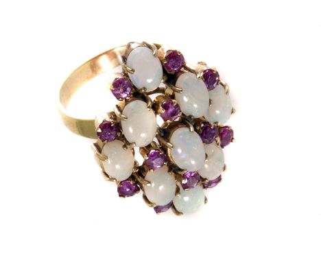 A gilt metal opal and ruby cluster ring, the stones alternatively grouped diagonally, composing of nine oval cut opals and tw