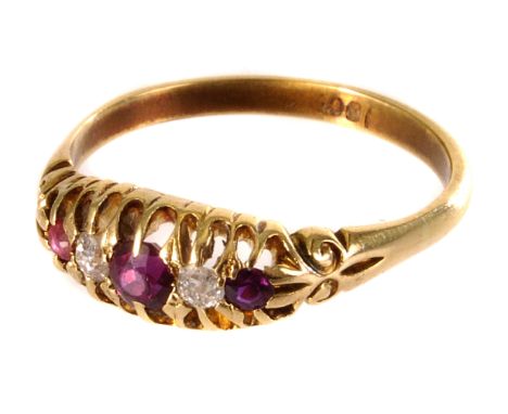 An 18ct gold ruby and diamond dress ring, the three graduated round cut rubies separated by single round cut diamonds, in pie
