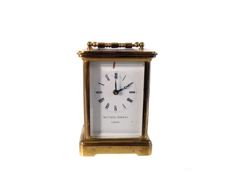 A Matthew Norman brass carriage clock, having black Roman numerals to white face, with bevelled glass surround, key present