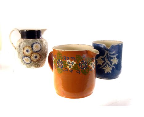 An assortment of ten ceramic water jugs, to include two similar orange ground pottery examples, florally decorated examples a