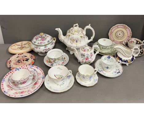 A collection of 19th century Staffordshire pieces with two teapots, saucers tureen, teapot stands, cups and saucers
