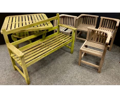 A set of four hardwood garden chairs, weathered, each measuring 65cm high x 63cm;  a garden bench, 83cm high x 120.5cm wide x