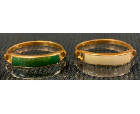 A green stone channel set dress ring possibly jade, yellow metal shank, stamped 750, size M/N;  another white stone, stamped 