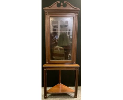 A 19th century style reproduction mahogany corner cabinet on stand, swan-neck pediment, glazed door enclosing two tiers of sh