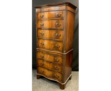 A George III style reproduction mahogany chest on chest, serpentine shaped front, seven graduated drawers, bracket feet, mid 