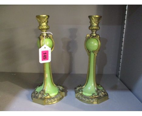 A pair of ceramic over gilt metal candlesticks