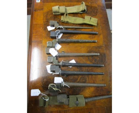 A group of Second World War and later stick bayonets, seven in sheaths, some with belt webbing, to include a No.4 Mk II bayon