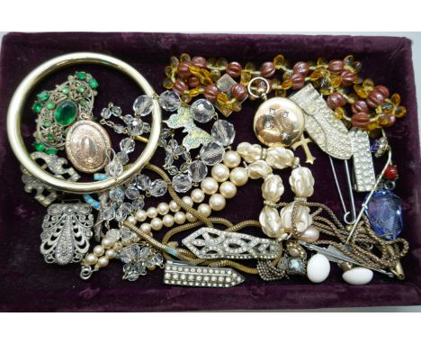 A collection of vintage jewellery including a horseshoe brooch, a Victorian locket, an early 20th Century locket, Czech style