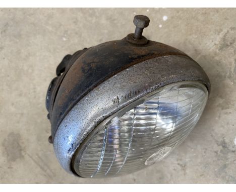A vintage Lucas 7" motorcycle headlamp with amp and switch, in good condition. 