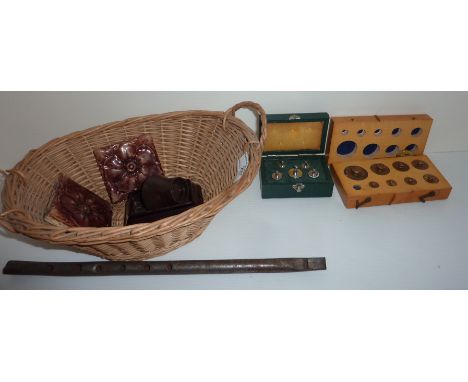Small wicker basket containing two ceramic tiles, penny whistle, Bakelite egg cup, cased sets of weights etc.