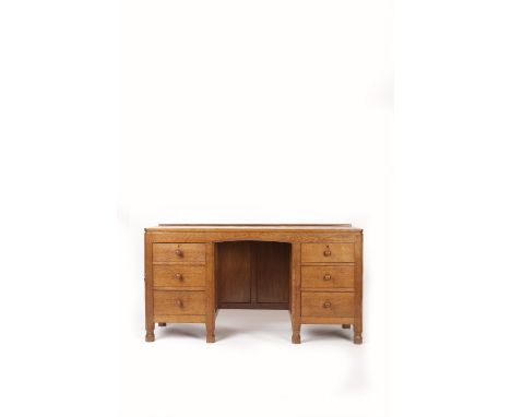 Robert Thompson of Kilburn (British, 1876-1955) Mouseman kneehole dressing table, circa 1950 oak, canted top with low rear ga