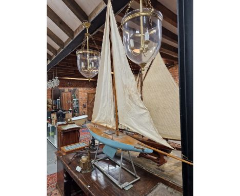 A BLUE HULLED POND YACHT NAMED WHO CARES, THE MAST SUPPORTING TWO SAILS, FROM STERN TO BOW SPRIT.   196cms.