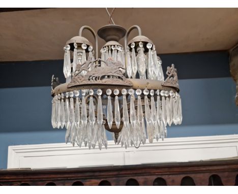 AN UNUSUAL LUSTRE HUNG BRASS CHANDELIER WITH TEN LIGHTS AND THE OUTER RIM WITH CHARIOTEERS.