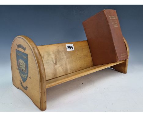 A BLONDE WOOD BOOK TROUGH WITH THE ROUND ARCH ENDS PRINTED WITH THE SHIELD OF HAILEYBURY COLLEGE AND THE DATE 1864.   W 33cms