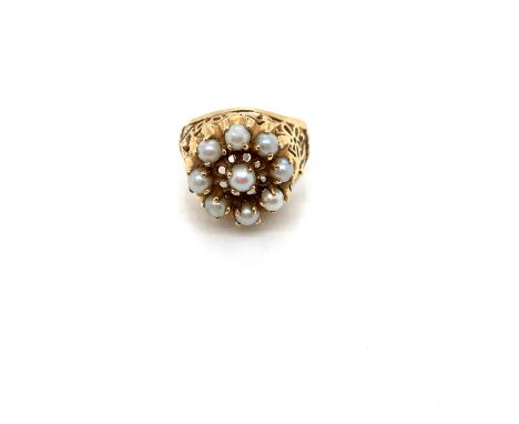 A PEARL CLUSTER RING. THE NINE PEARLS EACH IN A FOUR CLAW SETTING ON A RAISED FILIGREE AND PIERCED WORK SETTING. UNHALLMARKED