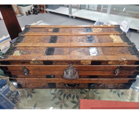 A LEATHER MOUNTED IRON BOUND WOODEN TRUNK WITH FOUR RAISED BARS ON THE RECTANGULAR LID.   W 85cms.