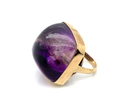 A LARGE DOMED SUGARLOAF AMETHYST RING IN A RUBOVER SETTING. DATED 1965, BIRMINGHAM. FINGER SIZE O. WEIGHT 29.36grms. 