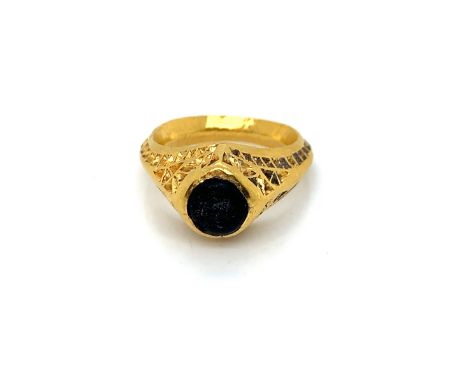 A MEDIEVAL ANCIENT GOLD RING WITH A BLUE / GREEN CENTRE STONE. THERE IS A INDISTINCT POSSIBLE MARK TO THE UNDERSIDE OF THE HE