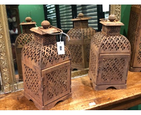 A PAIR OF IRON PRICKET CANDLESTICK LANTERNS, THE SIDES PIERCED WITH SCROLLS WITHIN DIAMOND DIAPER.   H 48cms.