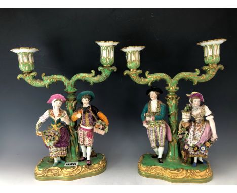 ATTRIBUTED TO EARLY VICTORIAN MINTON, A PAIR OF FIGURAL TWO LIGHT CANDELABRA, THE SUPPORTING COUPLES OFFERING FLOWERS AND FRU