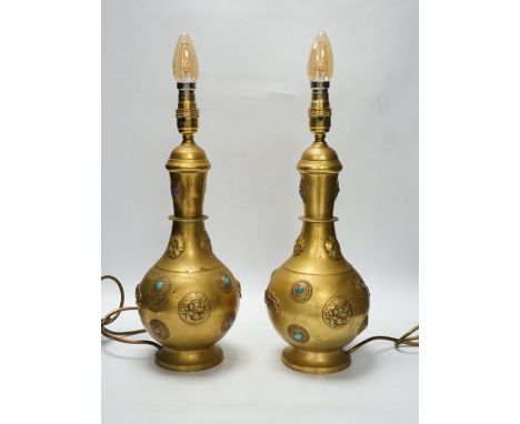 A pair of Sino-Tibetan gilt metal lamp bases set with cabochon stones