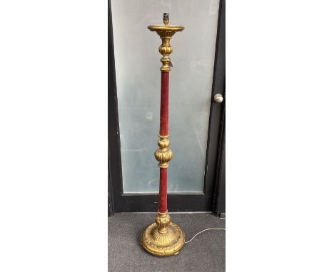 A gilt standard lamp with part fabric covered column