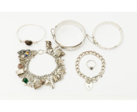A silver charm bracelet, suspending various various charms including pistol, car, armour, anvil, telephone dial, etc, a pewte
