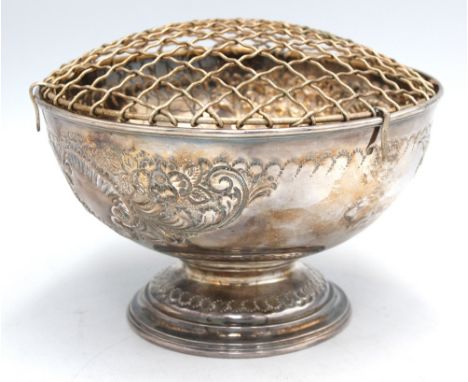 A late Victorian silver rose bowl, of usual form on footed base, body decorated with embossed scrolls of foliage and flowers,