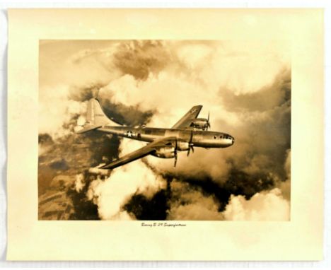 Original vintage war advertising poster for the Boeing B-29 Superfortress aeroplane flying above the clouds. Sepia toned phot